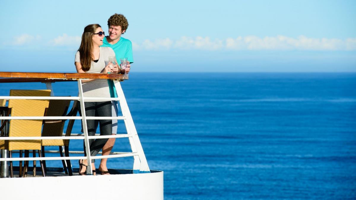 A couple on a blue cruise have a pleasant chat on the deck.